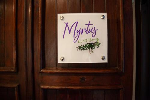 a sign on a wooden wall with the words murphys great house at Myrtus Guest House Cagliari in Cagliari