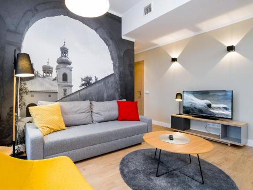 a living room with a couch and a tv at Riverside Aparthotel Cracow in Kraków