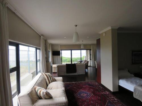 a living room with a couch and a table at Whalesong Villa in Hermanus