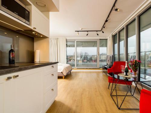 a kitchen and living room with a bed and a table at Riverside Aparthotel Cracow in Kraków