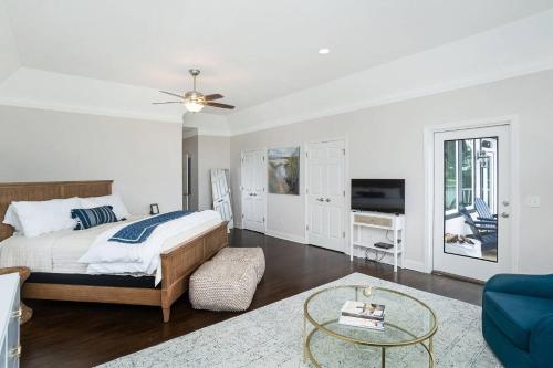 a white bedroom with a bed and a tv at Fairway to Heaven in Fripp Island