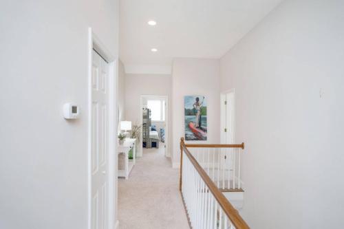 a hallway with white walls and a stairway at Fairway to Heaven in Fripp Island
