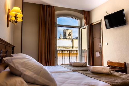 a hotel room with a large bed with a window at Hotel Reina Cristina in Granada