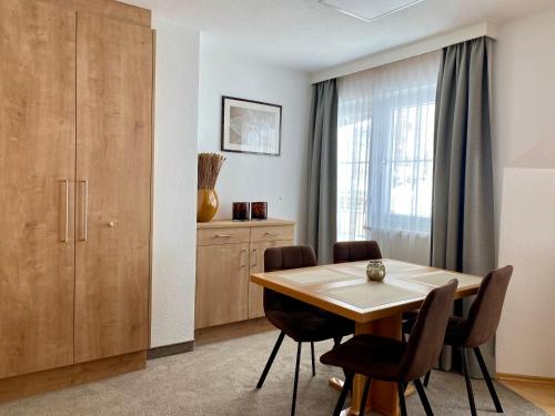 a dining room with a wooden table and chairs at Xenia Apartments in Kappl