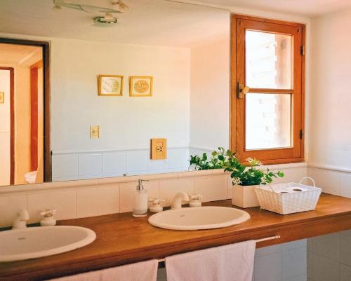 La salle de bains est pourvue de 2 lavabos et d'un grand miroir. dans l'établissement Casona Medrano, à Luján de Cuyo