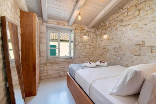 Postel nebo postele na pokoji v ubytování Lakka Stone House 1