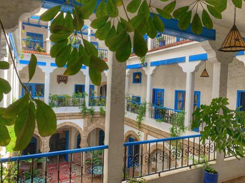 a building with blue doors and balconies at Riad Al Madina in Essaouira