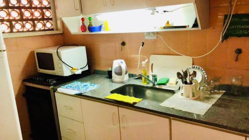 a kitchen with a sink and a microwave at Luminoso departamento en el corazón de Olivos in Olivos