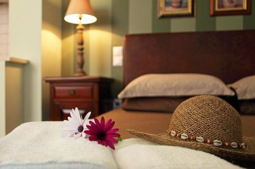 a hat with a flower on top of a bed at Anthias Garden in Lefkada Town