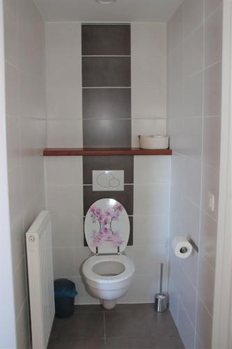 a bathroom with a toilet with a flowery lid at Juwel Fruithof in Zepperen