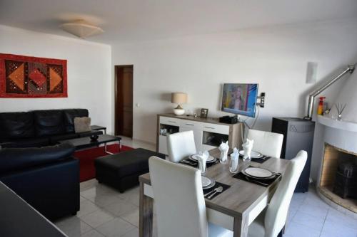 a living room with a dining table and a couch at Casa Franki - Stylish and large beach apartment in Algarve in Carvoeiro