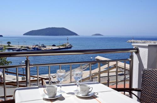 a table with two glasses and a view of the ocean at Oasis Deluxe Apartments in Neo Klima