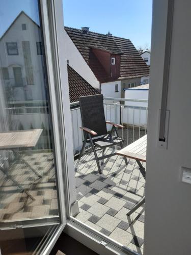 een balkon met een stoel en een tafel bij Pension Assmann in Langenbruck