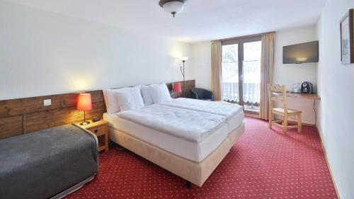 a hotel room with a bed and a desk at Le Chamois in Les Diablerets