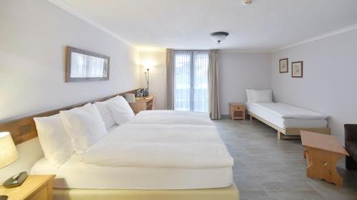 a hotel room with two beds and a television at Le Chamois in Les Diablerets