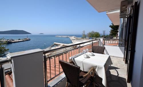 a balcony with a table and chairs and the water at Oasis Deluxe Apartments in Neo Klima
