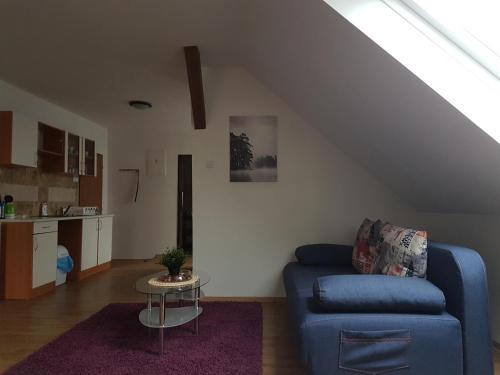 a living room with a blue couch and a table at Penzion Zelený Háj in Merklín