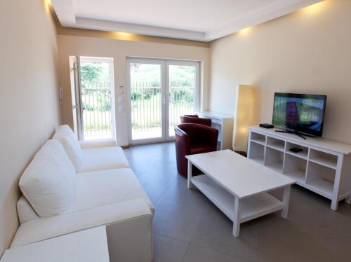 a living room with a white couch and a tv at Roof of Africa Hotel in Windhoek
