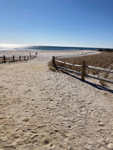 a fence on a beach with the ocean in the background at Surfside Motel - Seaside Heights in Seaside Heights