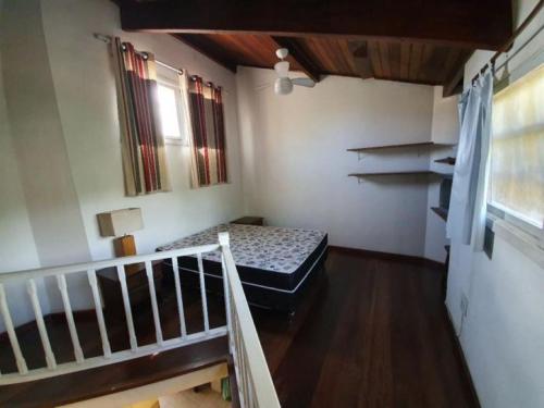 a small room with a bed and a staircase at Casa em Camburi in Camburi