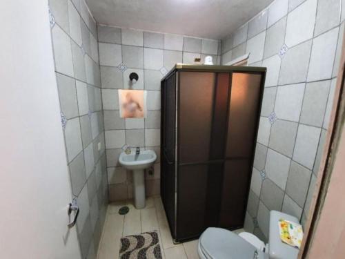 a small bathroom with a toilet and a sink at Casa em Condominio Camburi in Camburi