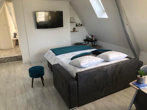 une chambre avec un lit et une télévision sur un mur dans l'établissement Charmant appartement au coeur de Bayeux, à Bayeux