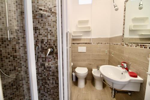 a bathroom with a toilet and a sink and a shower at Gabbiano 5 in San Vincenzo