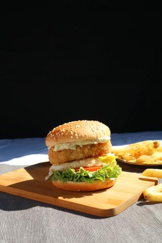 a sandwich on a wooden cutting board with fries at Dongshan River Left Bank in Wujie