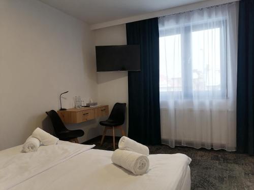 Habitación de hotel con 2 camas, escritorio y ventana en Pokoje Hotelowe LUPUS en Gołdap