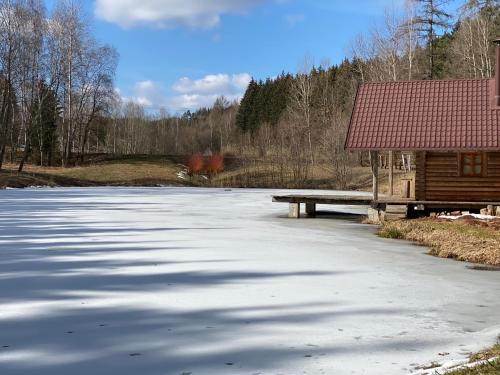 a frozen lake with a bench and a building at SG chalupa ŠTIKOV - Podkrkonoší - s celoročním privátním wellness in Nová Paka