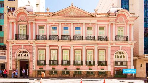 a pink building with people standing in front of it at Vila Galé Rio de Janeiro in Rio de Janeiro