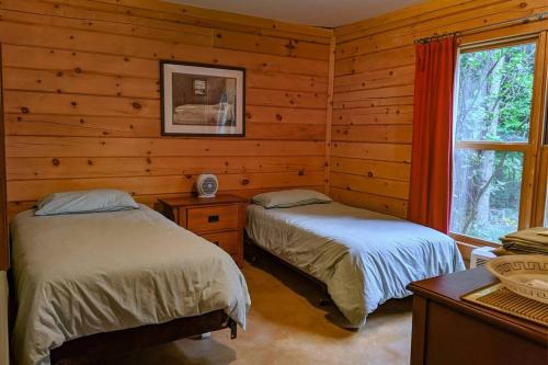 a bedroom with two beds in a log cabin at Chalet Le Boisé in Wakefield
