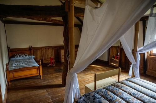 an attic bedroom with two beds and a canopy at Chambres d'hôte en Dordogne in Beauronne