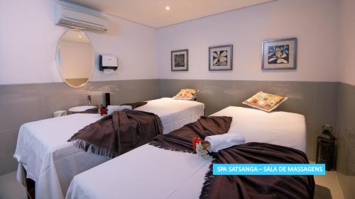 a room with three beds and a mirror at Vila Galé Rio de Janeiro in Rio de Janeiro
