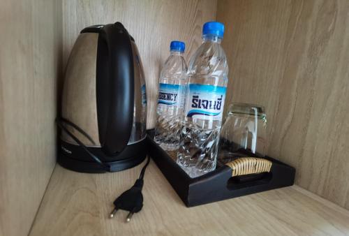 a black cat standing next to a blender with water bottles at TD Bangkok in Bangkok