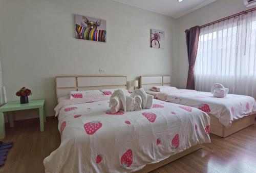 a bedroom with two beds with stuffed animals on them at TD Bangkok in Bangkok