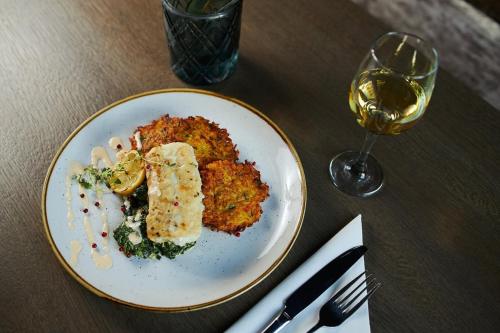 un piatto di cibo su un tavolo con un bicchiere di vino di Dune Beach Luxury Suites a Mielno