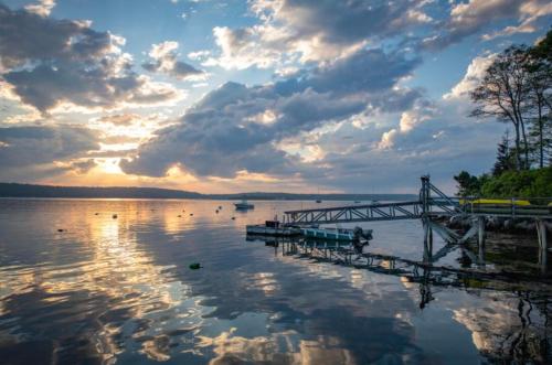 a dock on a body of water with a sunset at Smuggler's Cove Inn in Boothbay