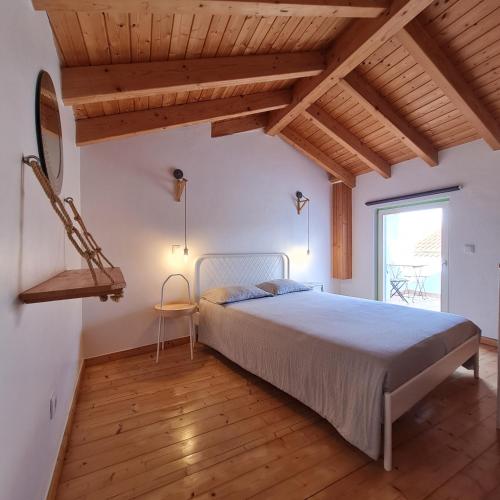 1 dormitorio con 1 cama en una habitación con techos de madera en Casa Clara, en Odeceixe