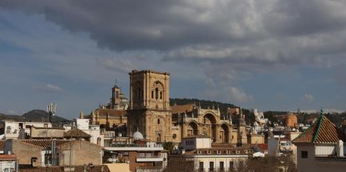an old building with a clock tower in a city at Hotel Reina Cristina in Granada