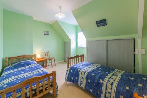 two beds in a room with green walls at Maison familiale avec jardin et terrasse à Saint-Cast-le-Guildo in Saint-Cast-le-Guildo
