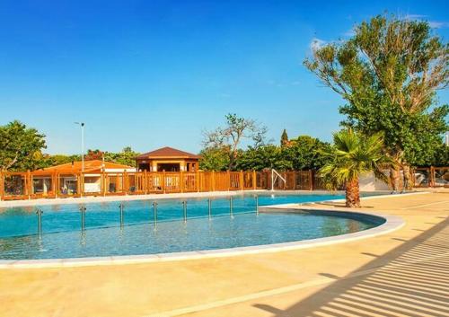 - une grande piscine dans une cour avec une maison dans l'établissement Le Solèou, à Port-la-Nouvelle