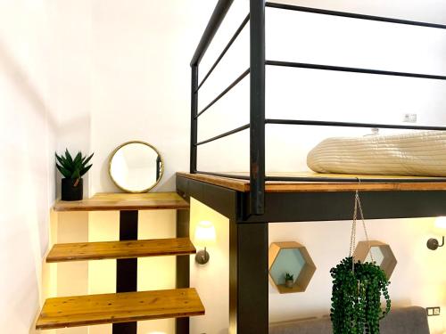 eine Treppe in einem Zimmer mit einem Bett und einem Spiegel in der Unterkunft Homely Malaga Refino Loft D4 in Málaga