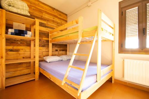 a bedroom with two bunk beds and a ladder at Alberg Vall d'Àger in Àger