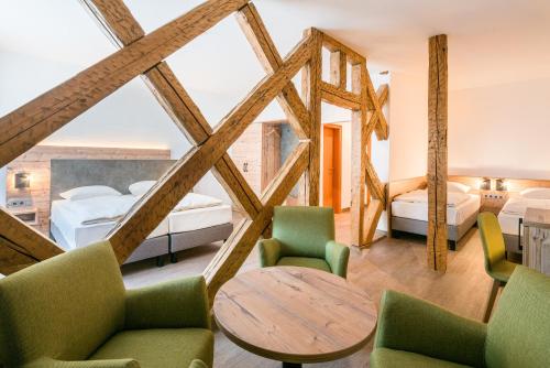 een slaapkamer met 2 bedden en een tafel en stoelen bij Hotel Café Adler in Triberg