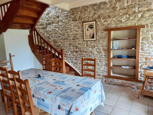 a room with a table and a stone wall at Maison confortable à Plehedel avec cheminée in Pléhédel