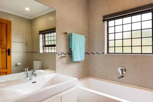 赫爾羅德灣的住宿－Agape holiday house，一间带水槽、浴缸和镜子的浴室