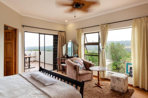 a bedroom with a bed and a large window at Agape holiday house in Herolds Bay