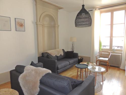 a living room with a couch and a table at Le Breuil - Spacieux, Chaleureux, Emplacement Idéal in Vesoul