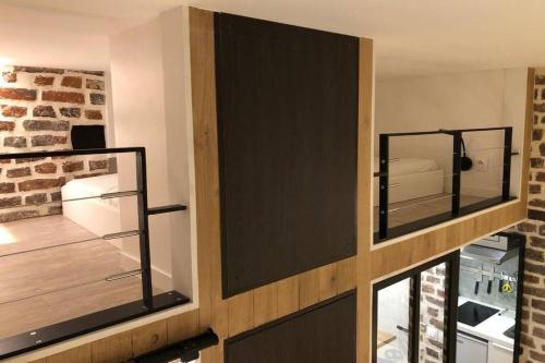 une chambre avec deux armoires en verre et un mur en briques dans l'établissement Studio Cinq Diamants, Neuf Tout équipé, à Paris